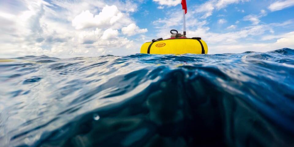 A floating tankless dive system on the ocean's surface pumps air to divers below.