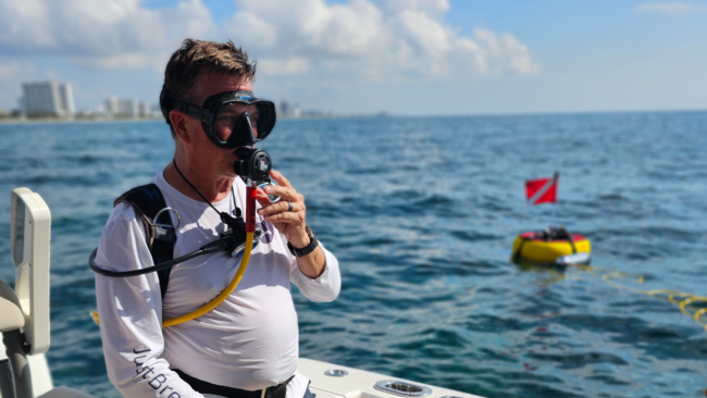 diver-getting-ready-with-sealion-dive-system Diver getting ready with the Sea Lion tankless scuba system on a boat.
