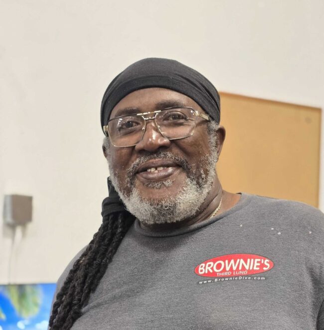Claude, Shipping Specialist at Brownie's THIRD LUNG, smiling and wearing Brownie's branded attire.