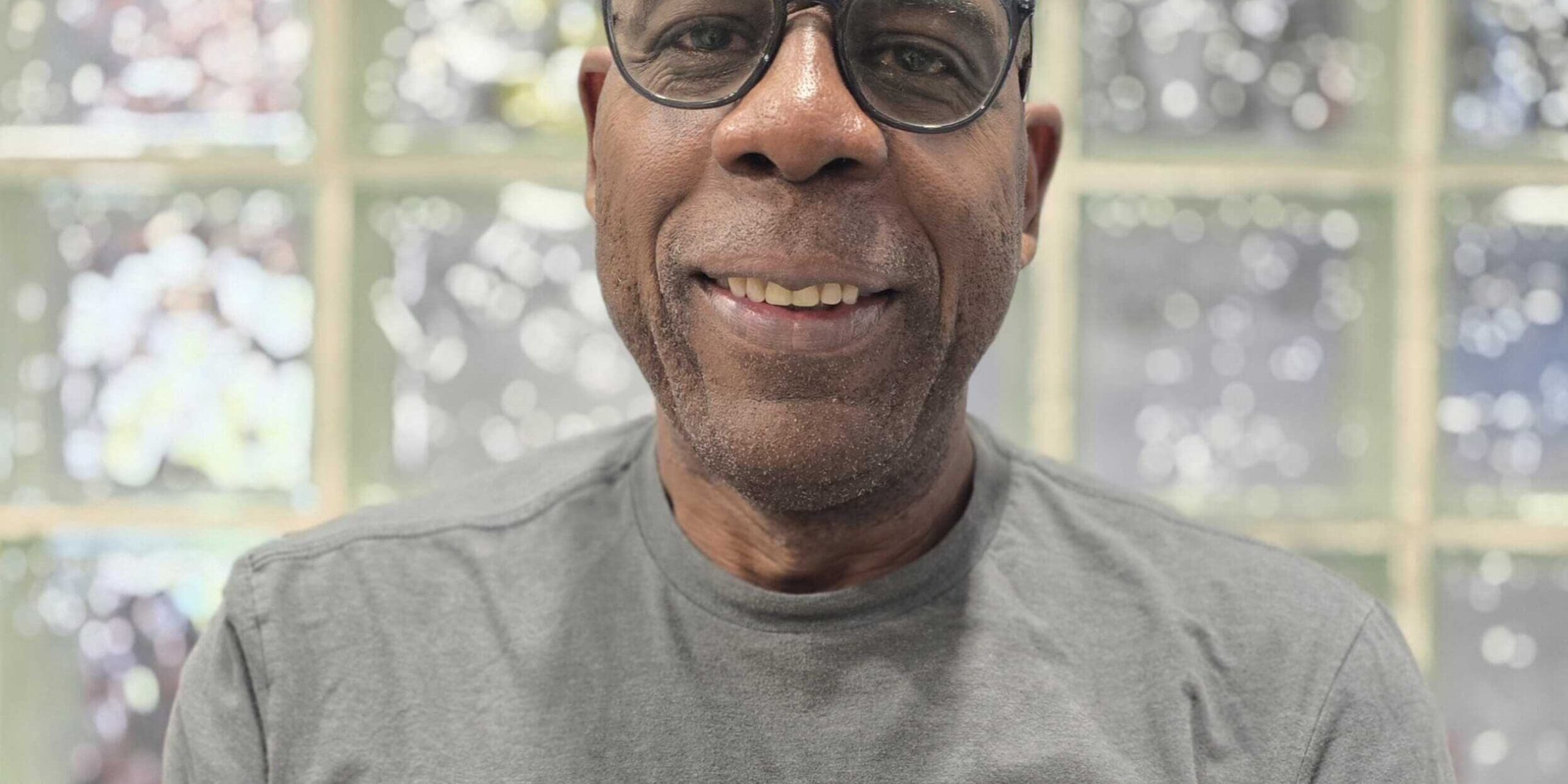 Herb, Technician at Brownie's THIRD LUNG, smiling in a gray Brownie's branded shirt