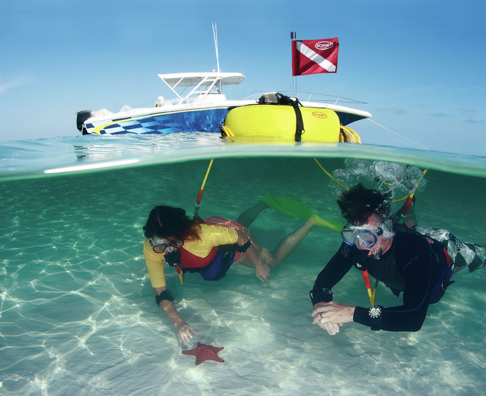 Two divers underwater with a Brownie's Third Lung floating at the surface