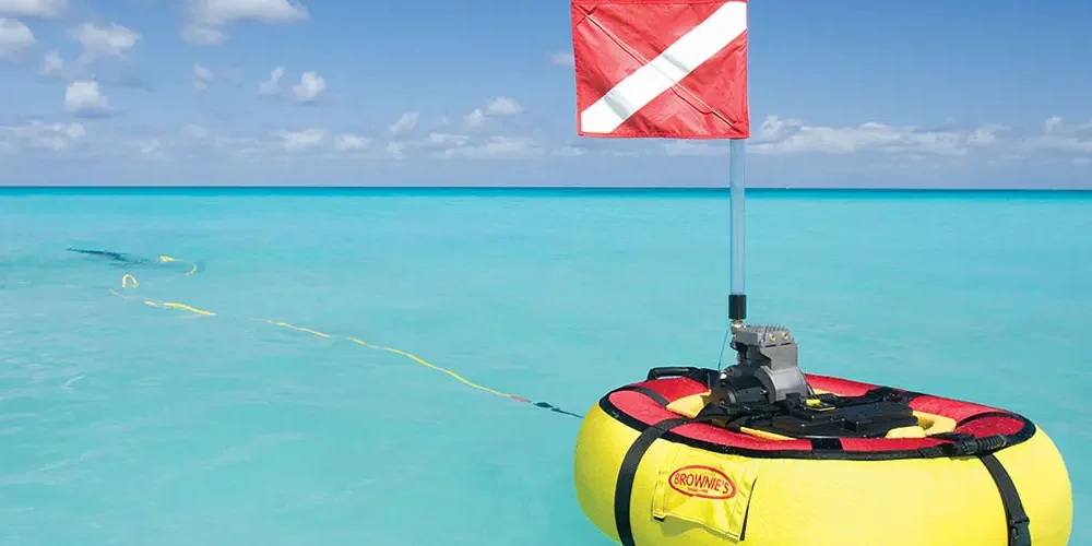 brownies-third-lung-floating-dive-system-clearwater-banner.webp Tankless dive system floating on the water with two divers swimming in the background