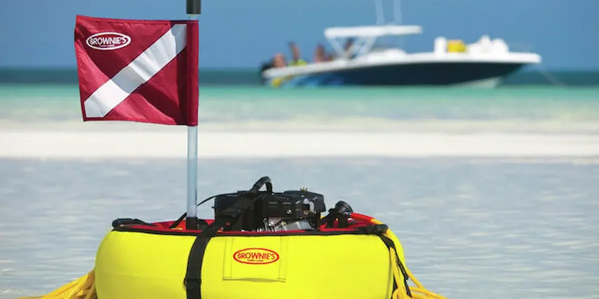 Brownie's gas powered tankless dive system floating on a sandbar with a boat in the background
