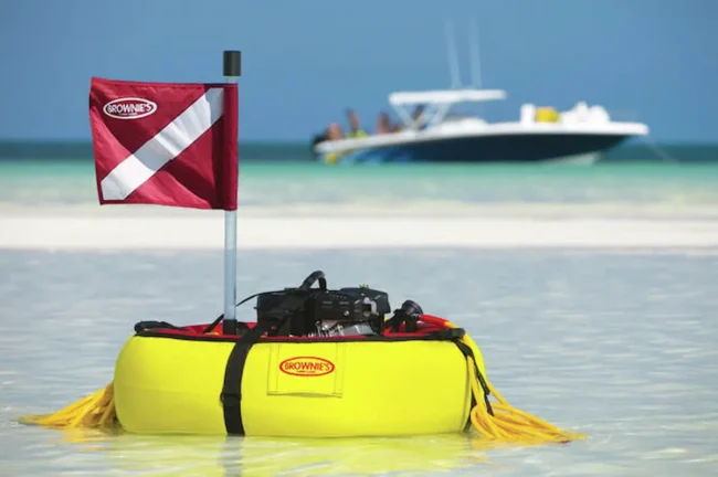 Brownie's gas powered tankless dive system floating on a sandbar with a boat in the background